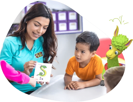 Preschool teacher holding S flashcard with student